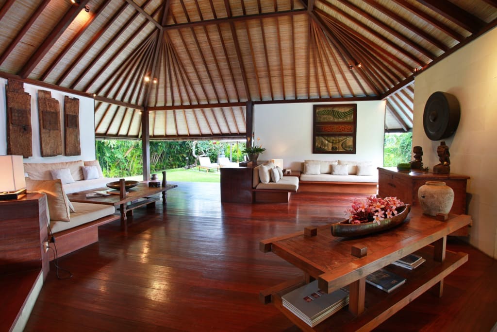 Traditional Balinese living room with hard wood floors, high ceiling with thatched roof. Large open plan living area in Luxury villa. A great villa in Bali to buy